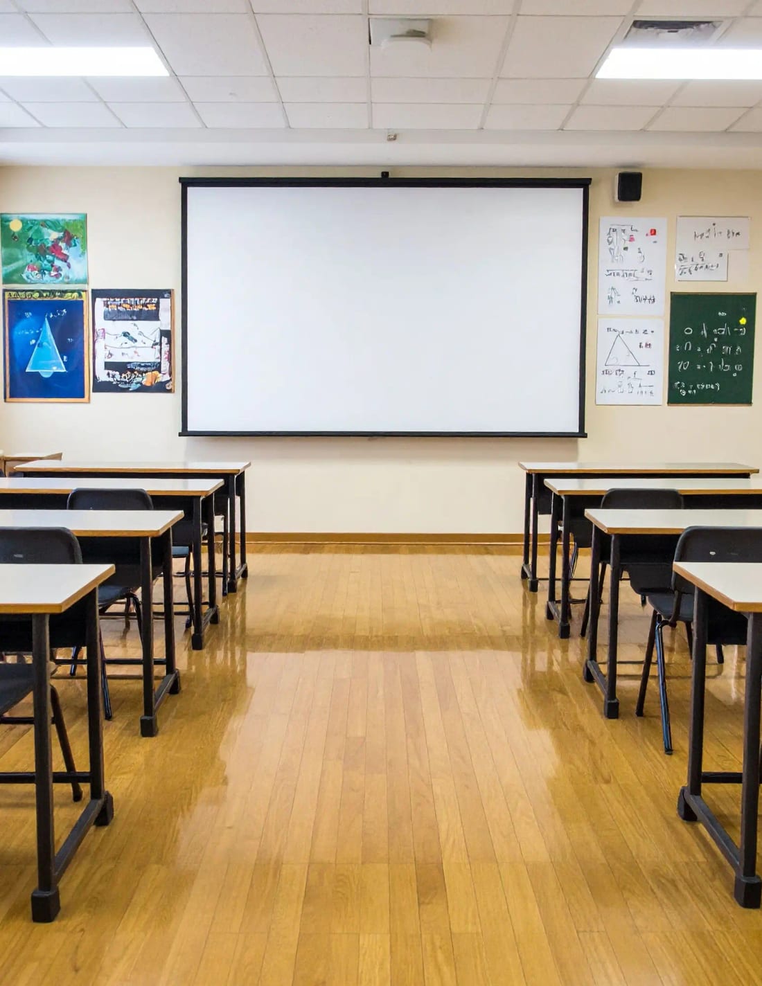 A bright, tidy classroom with student artwork and a projector screen ready for a lesson