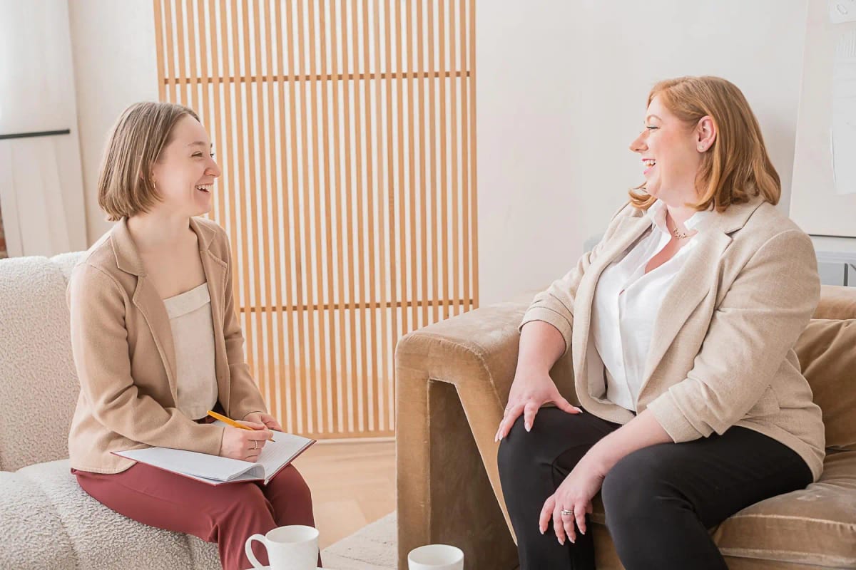 Two leaders in a coaching conversation in a warm office setting