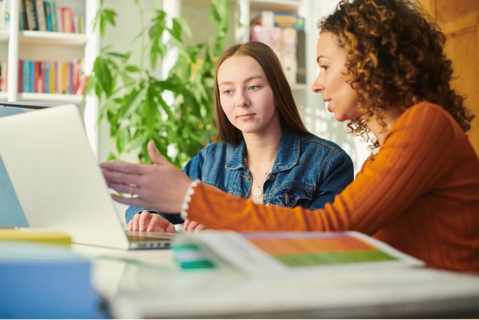 A career counsellor reviewing options with an employee at a laptop