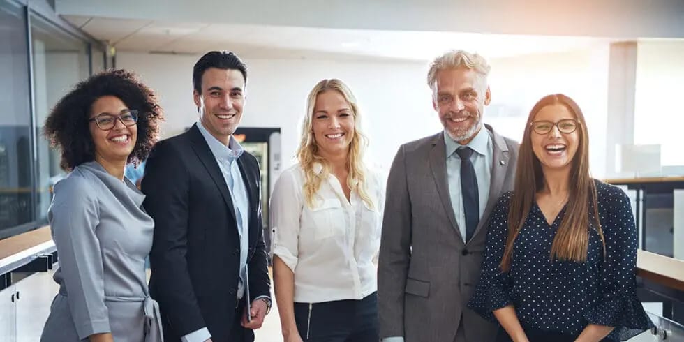 A team of five professionals standing together