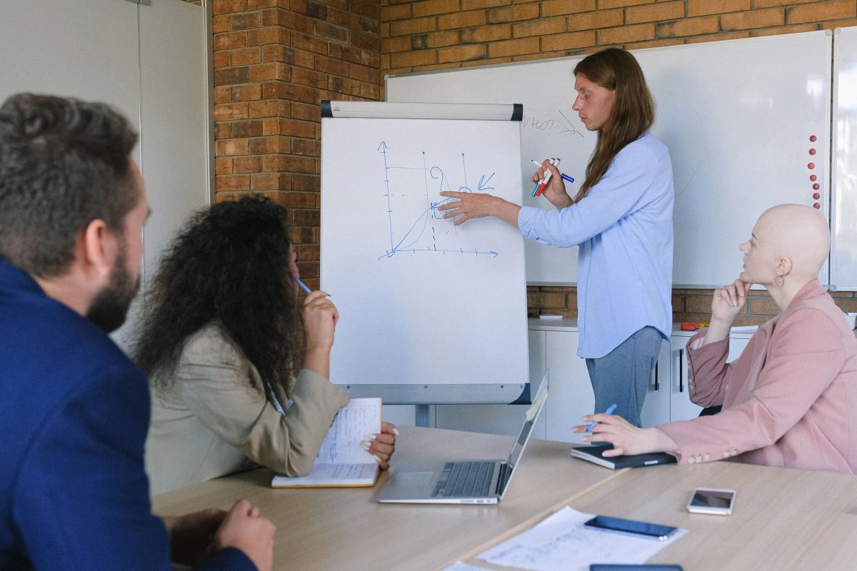 A facilitator sketching a model on a flipchart for a seated group